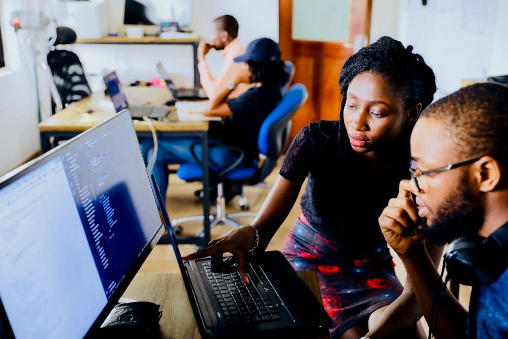 Technology engineers and developers collaborating on modern artificial intelligence software and multi-screen workstation